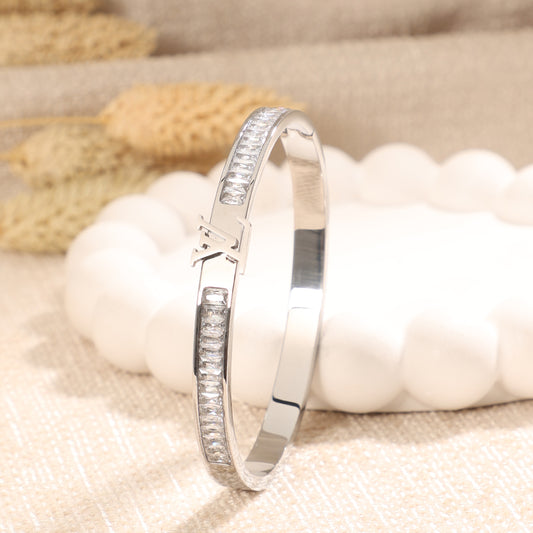 Silver Toned Crystal Baguette Bangle with Logo Accent